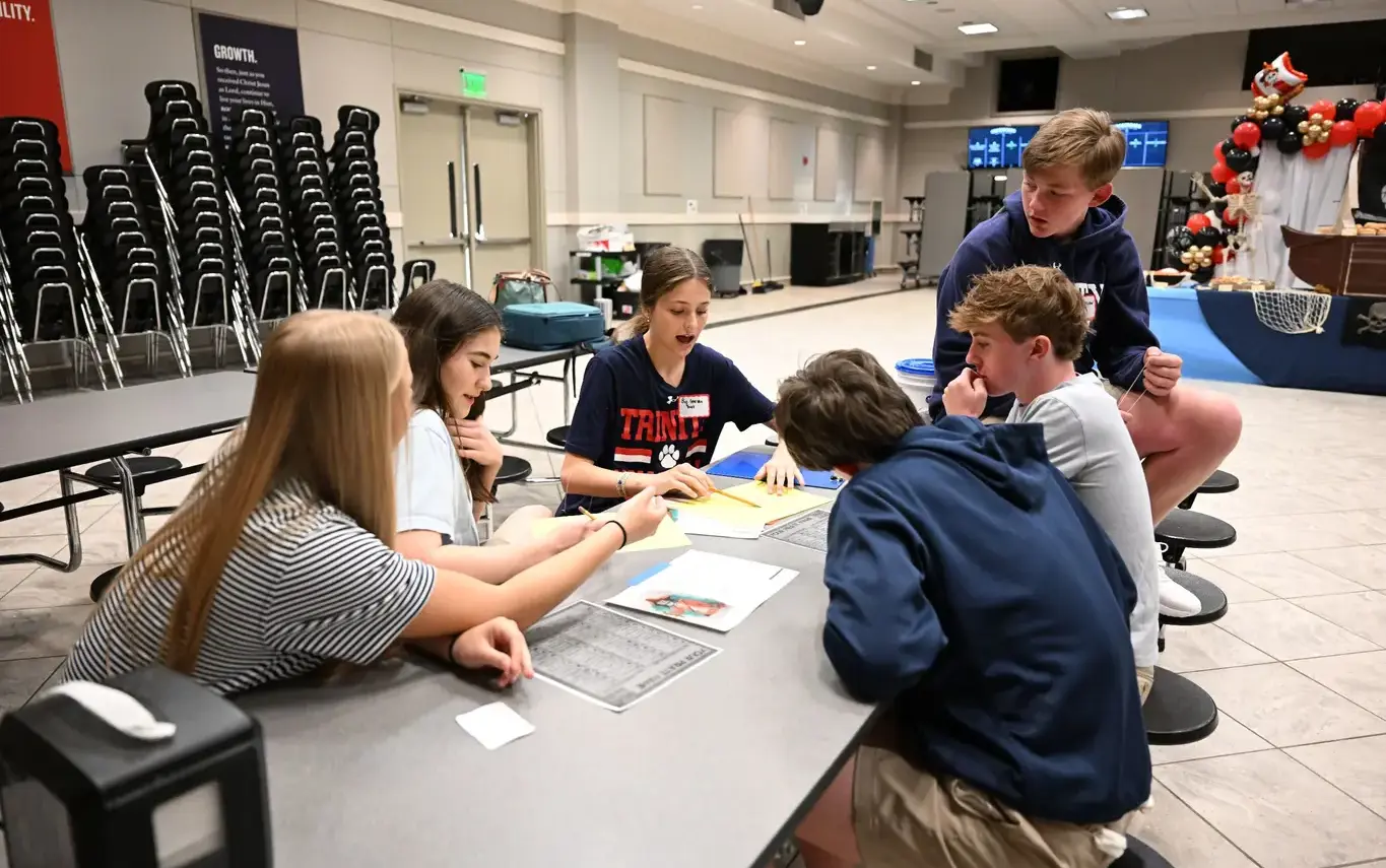 middle school kids sitting at a table doing group workon page image
