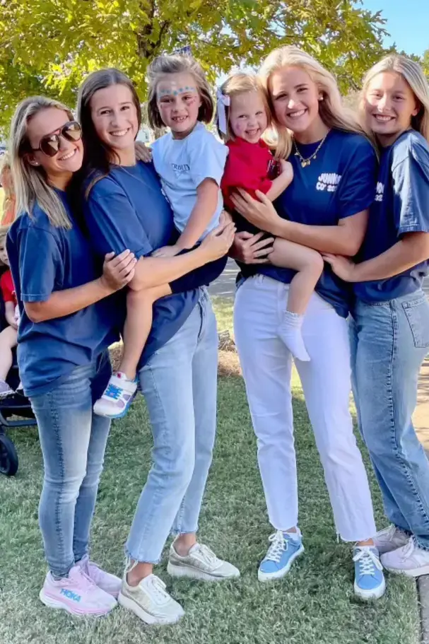 group of older students holding younger students on their armon page image