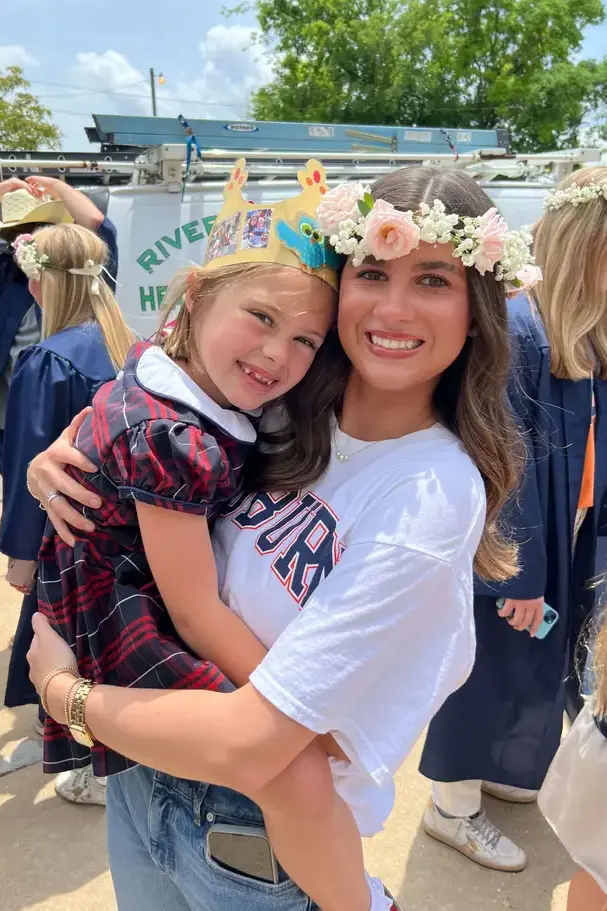 Older girl holding younger girl at school celebrationon page image