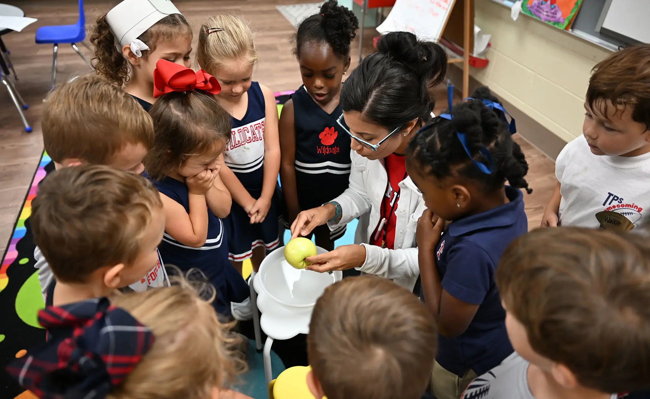 Teacher peeling an apple in front of students